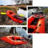 Orangefarbenes aufblasbares PackRaft am Ufer eines klaren Gewässers, mit einem Fahrrad darauf drapiert, ideal für Bikepacking und Wasserabenteuer im Freien.