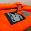 Secumar Rettungsweste Bravo für Kinder im Gewicht von 20-30 kg, orangefarbene Schwimmweste auf Holzuntergrund, hohe Sichtbarkeit und Sicherheit im Wasser.